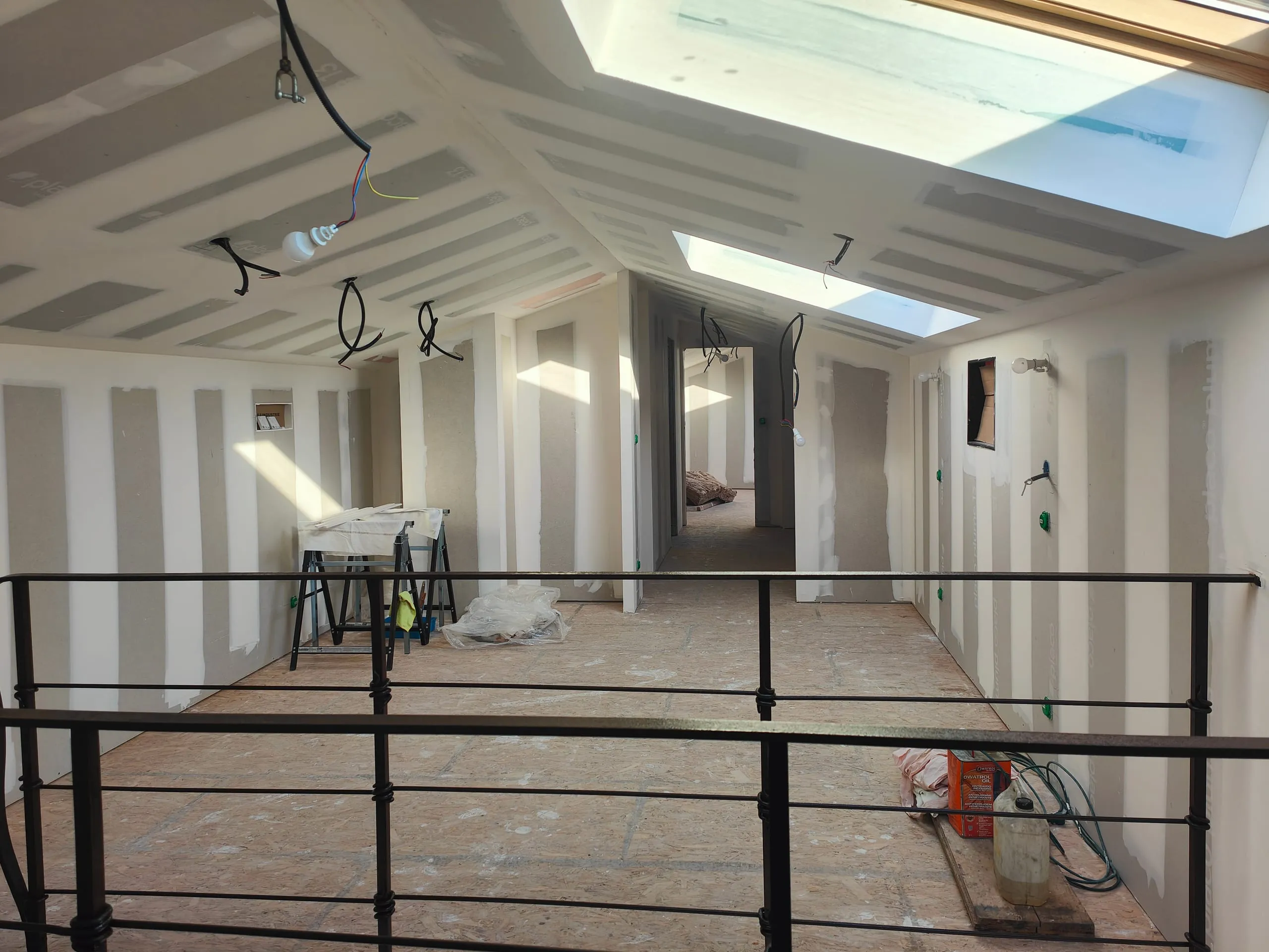 Pose de plaques de plâtre et réalisation des joints dans un intérieur en rénovation.