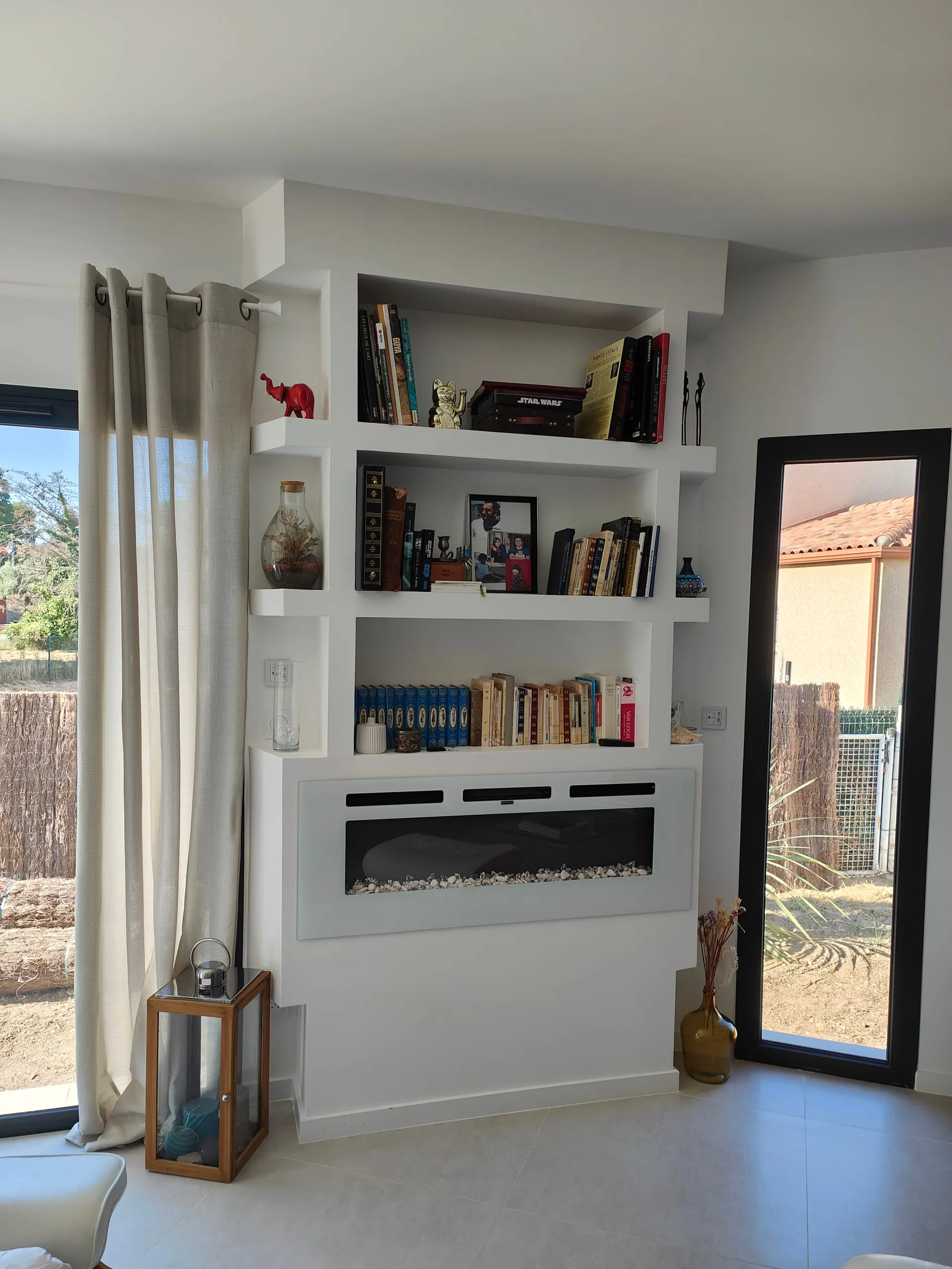 Bibliothèque intégrée et habillage de cheminée en placo dans un intérieur lumineux.