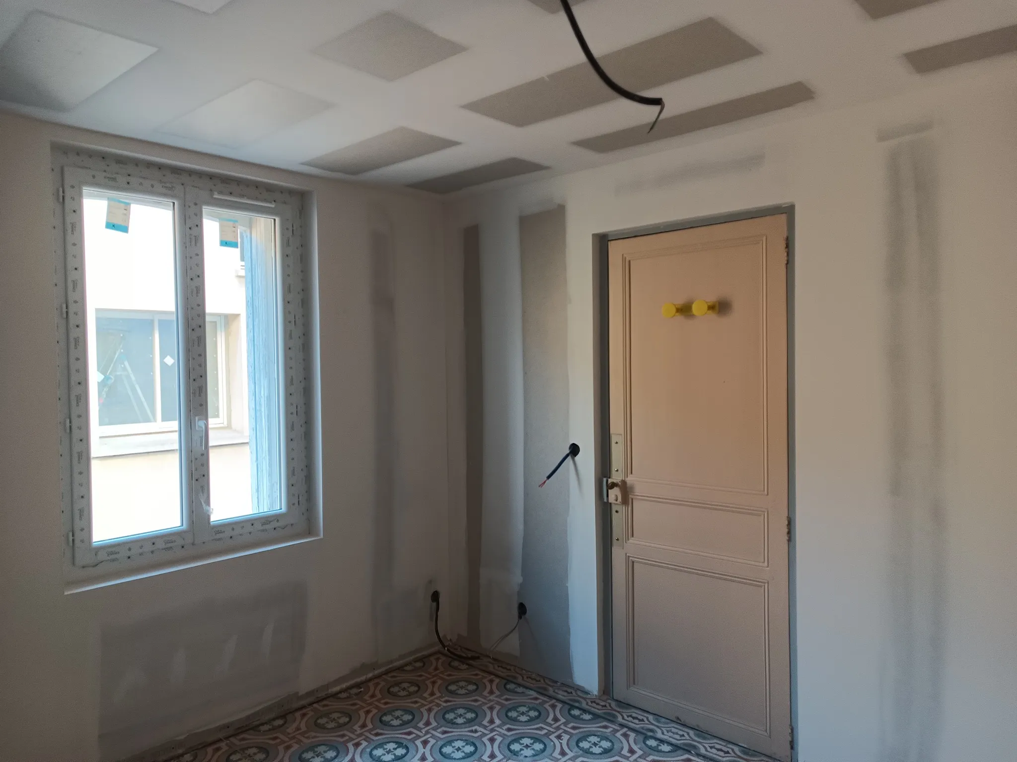 Chambre avec fenêtre neuve, plafond en plaques de plâtre et porte ancienne